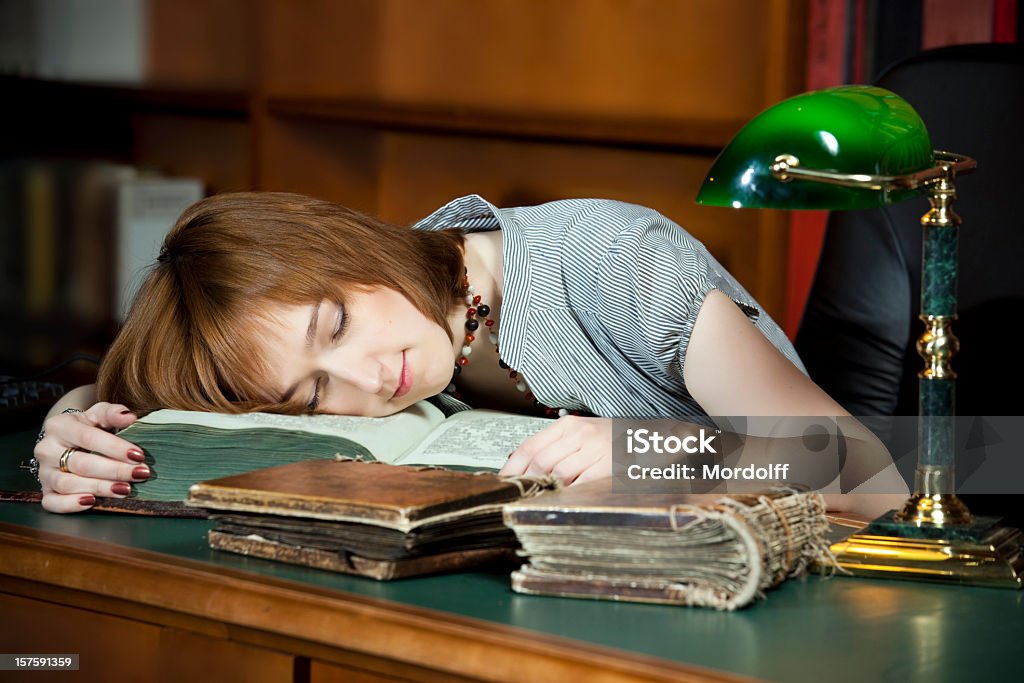 Junge Frau Schlafen auf alte Bücher in der Bibliothek - Lizenzfrei Attraktive Frau Stock-Foto