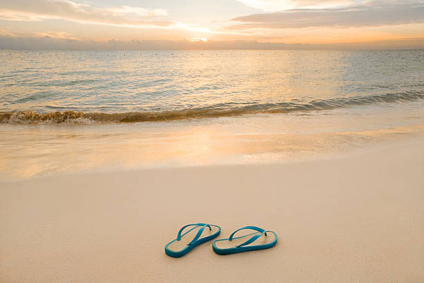 istock Sandals On The Beach By A Smooth Sunrise 157591408