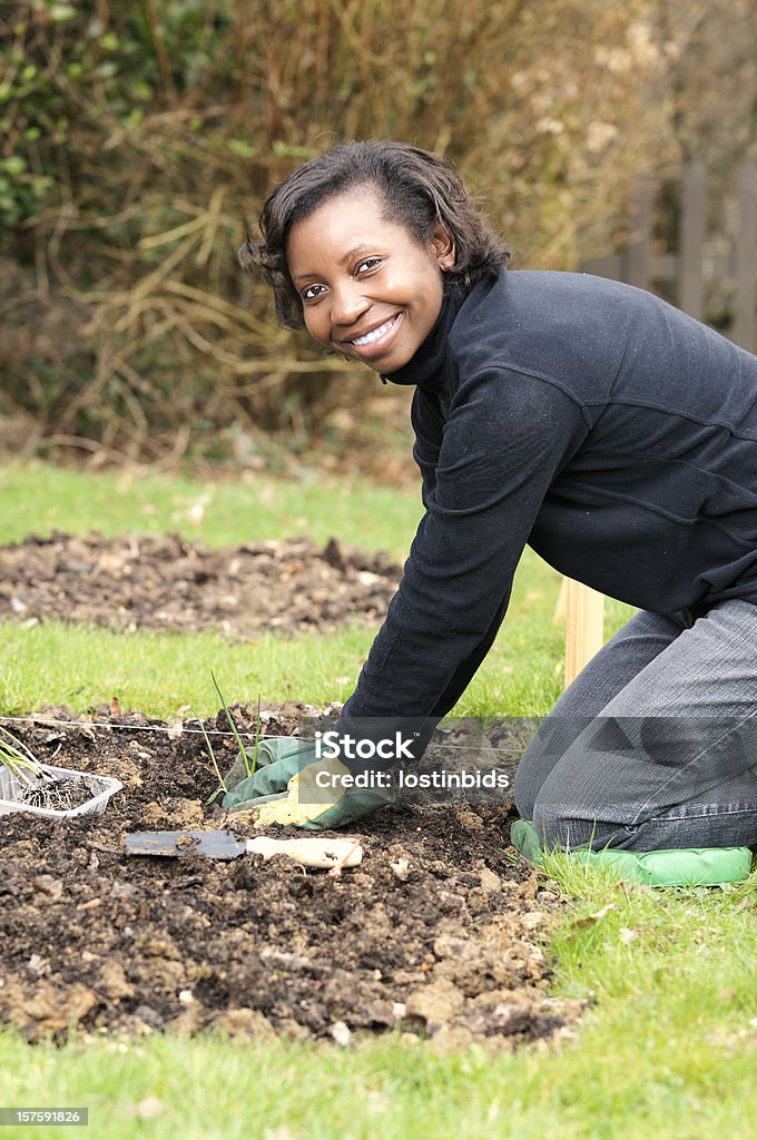 African American kniend auf und Pflanzen Schalotten und Zwiebeln - Lizenzfrei Pflanzen Stock-Foto
