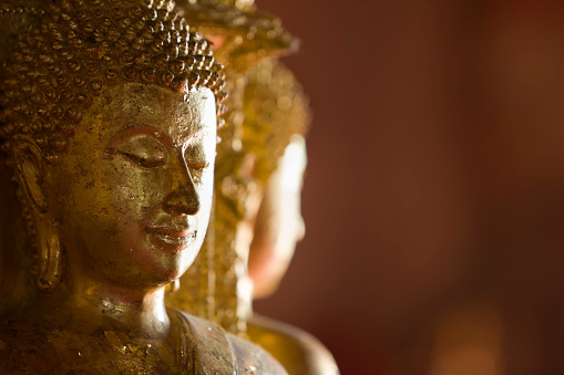 A majestic Buddha statue stands proudly in Wat Doi Phra Chan, a Buddhist temple located in Thailand