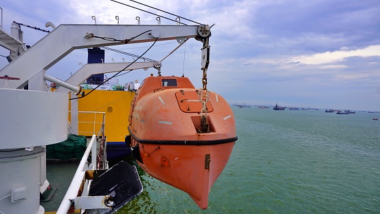 close up of safety emergency boat or lifeboat from the ship sea water and sky background