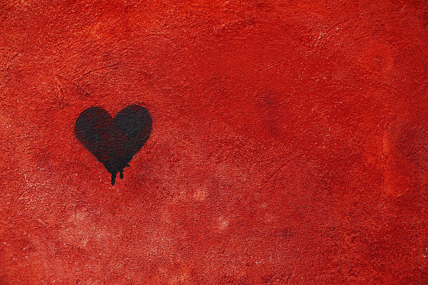 Graffiti heart spraypainted on red wall - Love Concept stock photo