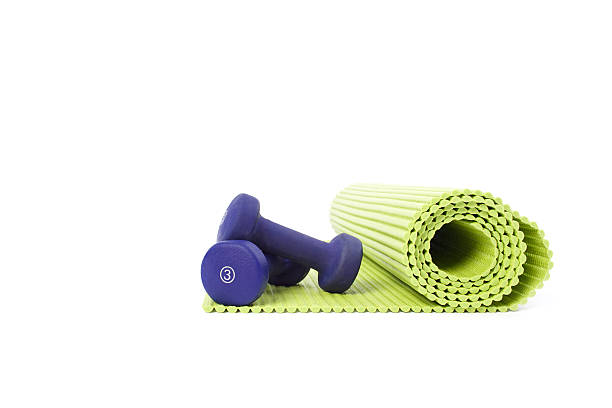 Yoga mat Yoga mat unrolled with small weights, isolated on white. exercise equipment stock pictures, royalty-free photos & images