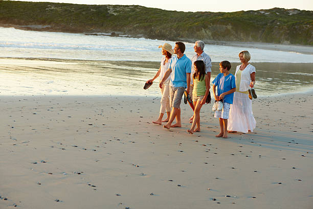 istock Happy three generational family walking together on beach 157592548