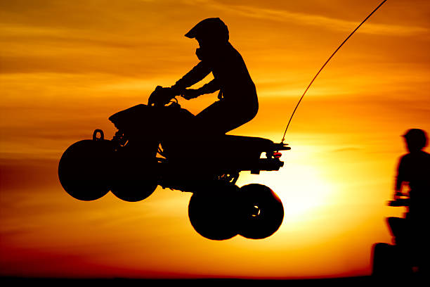 bicicleta de quatro lugares pulando ao pôr-do-sol - off road vehicle quadbike motocross desert - fotografias e filmes do acervo