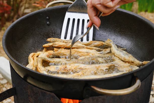 istock Small crispy fish fried in oil  in a pan on fire. 1575926289