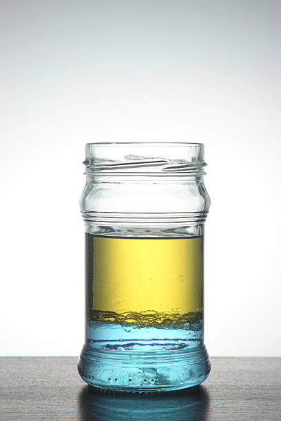 Front view of glass jar with olive oil and water in it