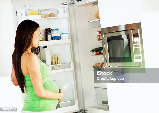 Junge Schwangere Frau Schaut In Den Kühlschrank Stockfoto und mehr Bilder von 25-29 Jahre - 25-29 Jahre, Anfang, Attraktive Frau