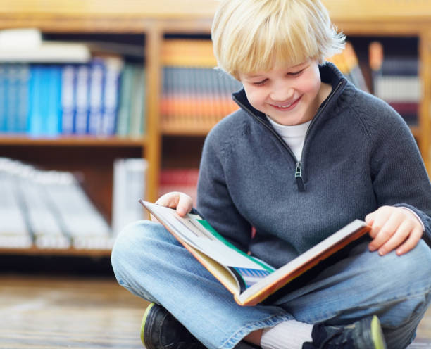 istock Innocent young boy reading a story book 157592747