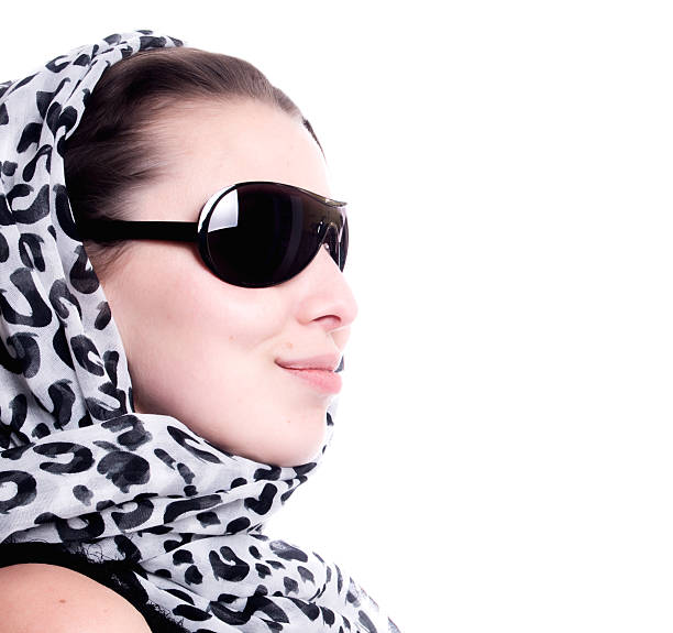 Portrait of a beautiful young woman, a fashion model, wearing a blue color headscarf, studio shot in front of a white background