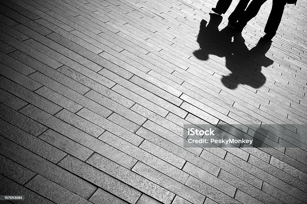 Shadow uomini d'affari a piedi sul lastricato di pietra grigia - Foto stock royalty-free di Mistero