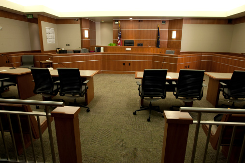Royalty free image showing a wide angle view of a modern courtroom setting from the gallery's point-of-view.  For more images of courtrooms as well as images featuring law and justice themes, click on these thumbnails: