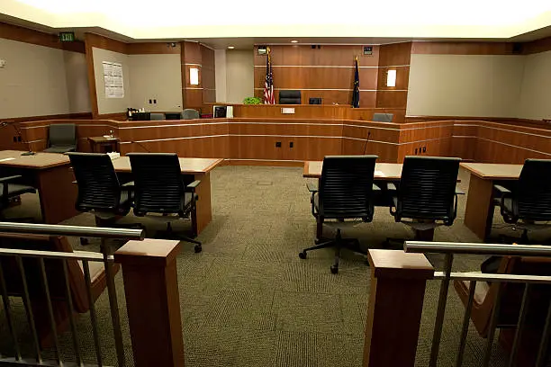 Royalty free image showing a wide angle view of a modern courtroom setting from the gallery's point-of-view.  For more images of courtrooms as well as images featuring law and justice themes, click on these thumbnails: