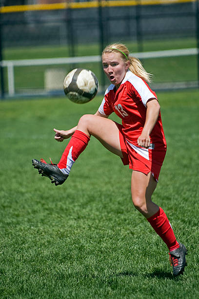Female Soccer Player Trapping Airborn Ball Royalty free image: female soccer player traps airborn ball. high school soccer stock pictures, royalty-free photos & images