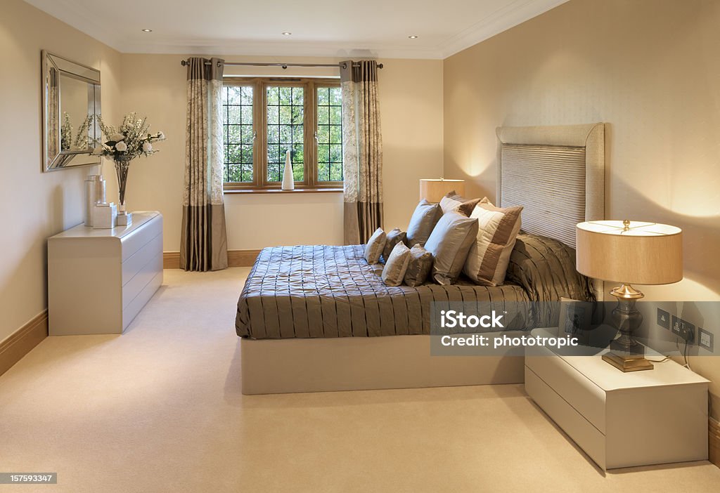 elegant bedroom an elegant guest's bedroom in an expensive new luxury house, decorated and furnished by a leading Interior Designer.  Night Table Stock Photo
