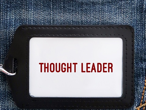 ID card holder on jeans background with text THOUGHT LEADER - buzzword used to describe someone considered expert in their industry, offers unique and influential  innovative insightful ideas