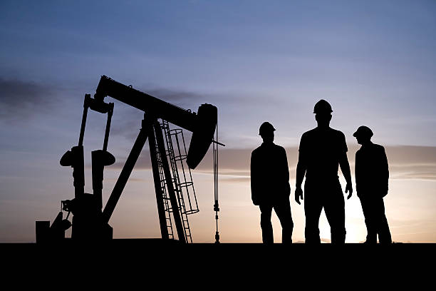 Three Oil Workers and an Pumpjack stock photo