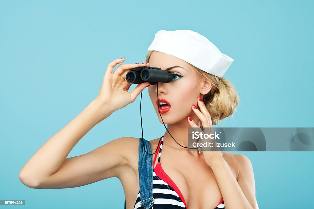 Pin-up estilo marinheiro mulher olhando através de binóculos - Foto de stock de Mulheres royalty-free