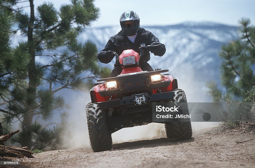 ATV che viaggiano lungo un sentiero del monte di polvere. - Foto stock royalty-free di Quad