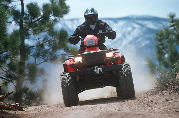 ATV traveling down a dust mountain trail. stock photo