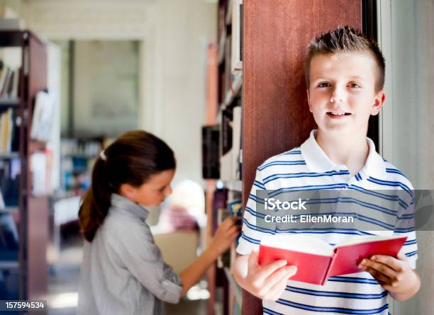 Photo libre de droit de Petit Garçon Lecture Dans La Bibliothèque banque d'images et plus d'images libres de droit de Adolescence - Adolescence, Apprentissage, Art du portrait