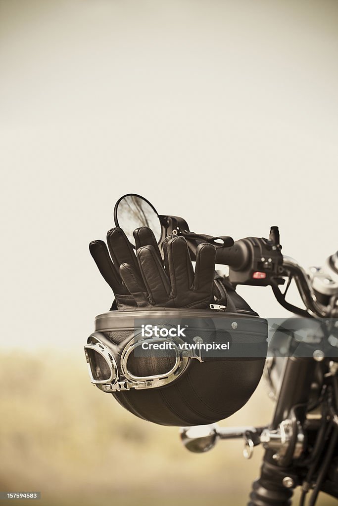 Vintage helmet and gloves on motorcycle Vintage leather helmet and gloves on vintage motorcycle handlebars. Short depth of field. Shot with 5DII. Motorcycle Stock Photo