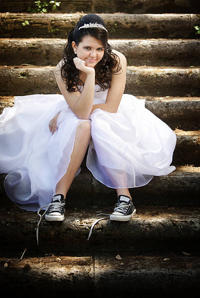 cool quinceanera modern quinceanera wearing cool tennis shoes seating on antique stone stair quinceanera stock pictures, royalty-free photos & images