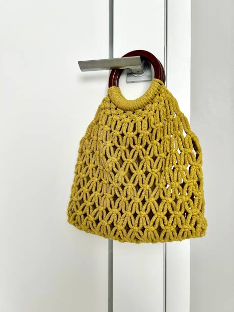 istock Handmade macrame bag on a light background. Eco-friendly women's bag made of organic macrame cotton. Hobby knitting macrame with your own hands. Modern summer concept. 1575958807