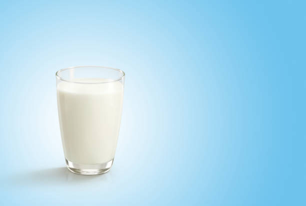 istock Glass of milk on blue white background 1575968499