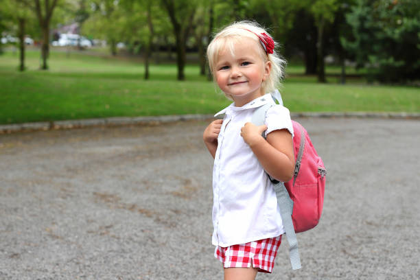 istock Little blonde girl with backpack going to study, lifestyle staging 1575976983
