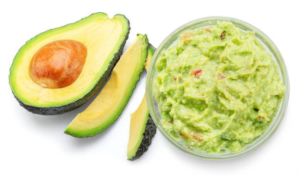 istock Guacamole and cross section of avocado fruit isolated on white background. 1575978575