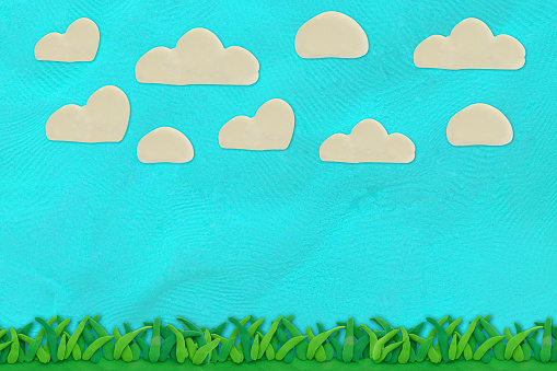 green grass and blue sky with cloud made from plasticine