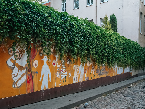 Vilnius, Lithuania - 07 15 2023: Yellow wall with street art in the center of Vilnius