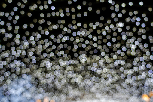 Abstract bokeh of white lights on black background. Christmas Lights