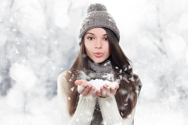 istock Winter portrait. Young, beautiful woman blowing snow 157601256