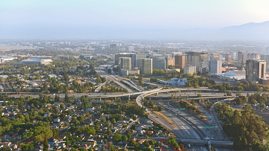 Aerial view of freeway interchange against modern buildings in San Jose, California, USA.