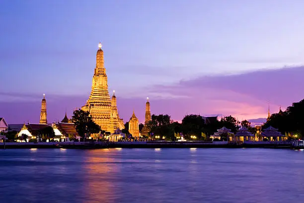 Twilight view of Wat Arun across Chao Phraya River during sunset in Bangkok, Thailand