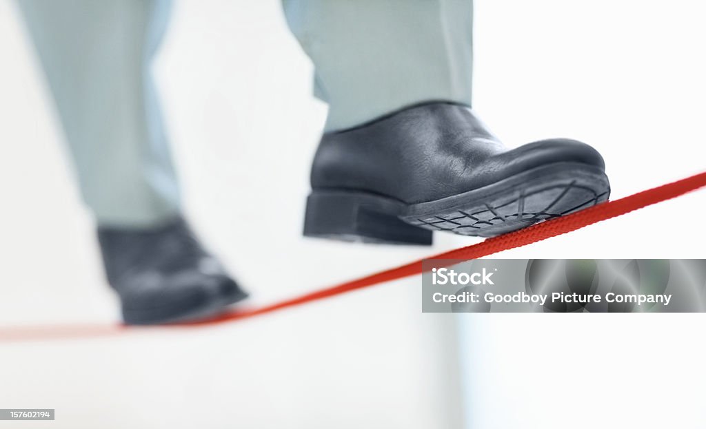 Hombre de negocios caminando en la thin line que representan la incertidumbre tarea - Foto de stock de Cuerda Floja libre de derechos