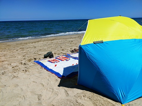 beach towels and umbrella on the beach near the seashore