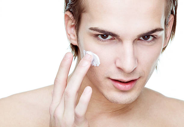 istock Man applying cosmetic cream on face 157602323