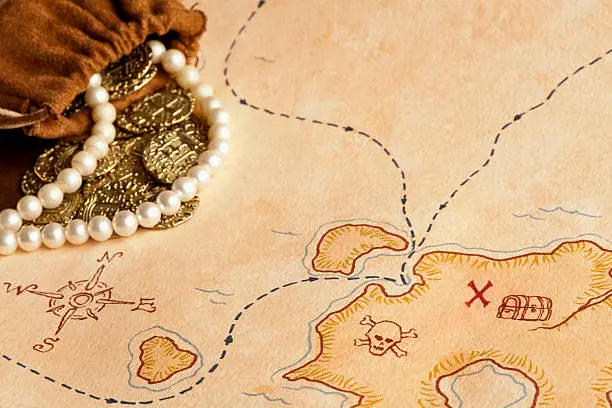Selective Focus on this Treasure Map with Gold Coins and Pearls.