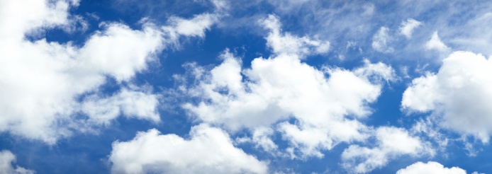 A Detailed Image Of White Fluffy Cumulus Clouds Set Against A Blue Daytime Sky In Banner Image Format