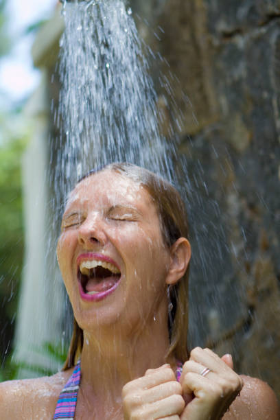 Young woman taking a cold outdoor shower  shower women falling water human face stock pictures, royalty-free photos & images