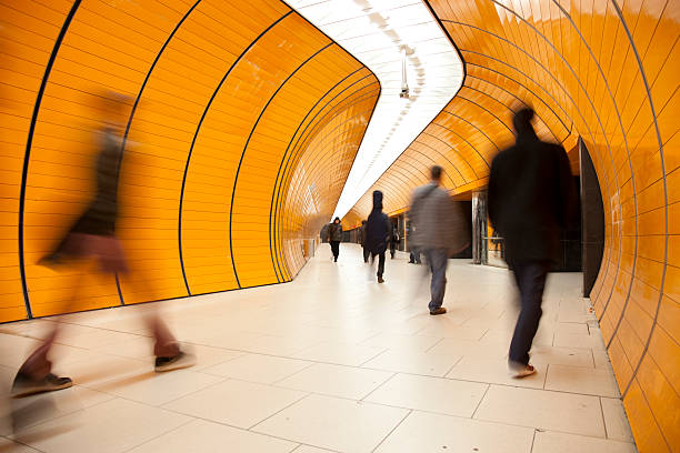 rushing commuters against modern orange background stock photo