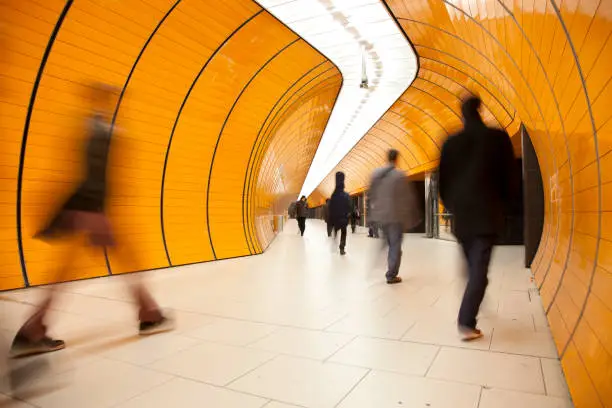 Photo of rushing commuters against modern orange background