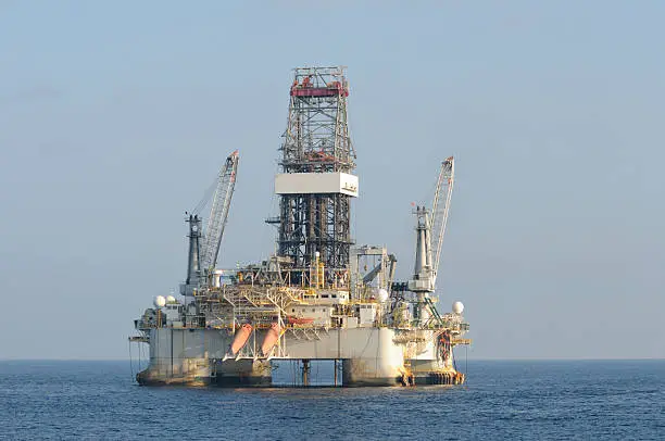 A floating deep water dynamically positioned semi-submersible oil drilling on location at sea.