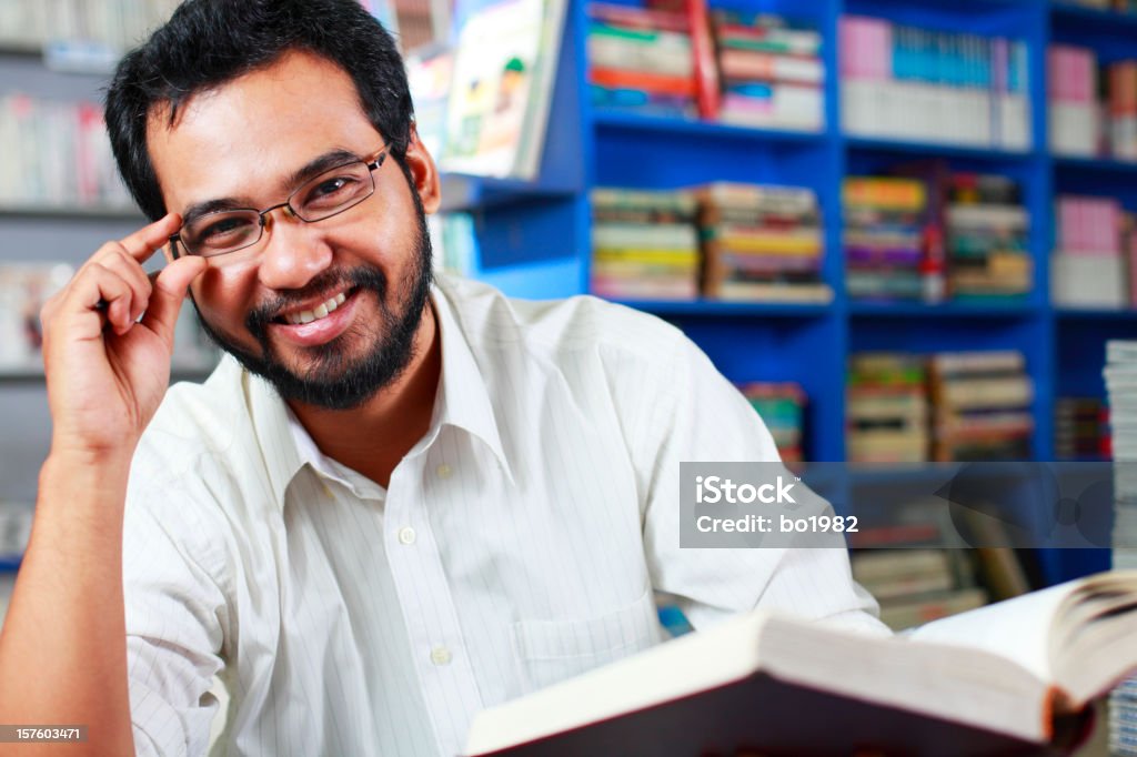 Счастливый молодой Профессор в библиотеке - Стоковые фото Индийского происхождения роялти-фри