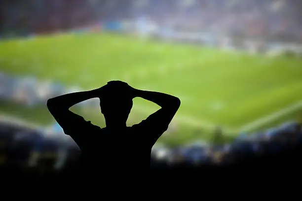 Fan with hands on head in disgust at soccer/football game