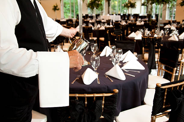 recepción de boda camarero verter agua en gafas. waitstaff. sirve. - table wedding flower bow fotografías e imágenes de stock