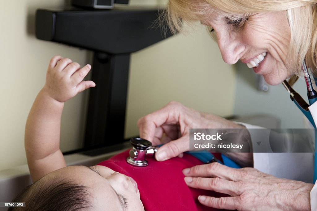 Médico usando Stethascope en un bebé - Foto de stock de 60-69 años libre de derechos